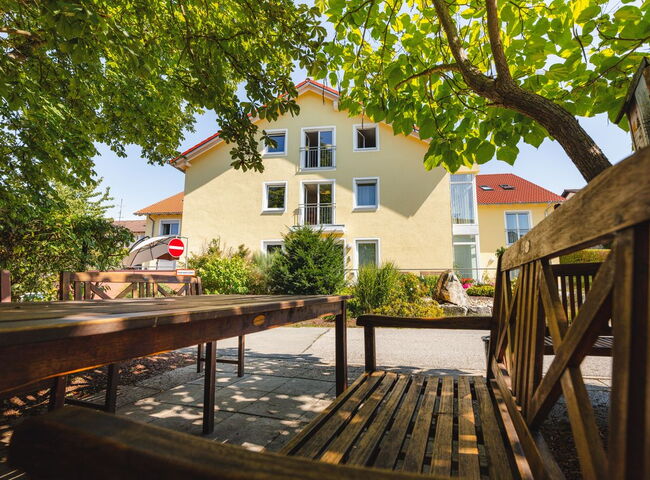 Eine Sitzgarnitur im Schatten vor dem Seniorenheim St. Michael