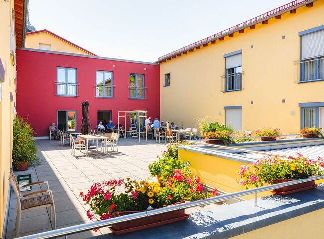 Bewohner sitzen im sonnigen Innenhof